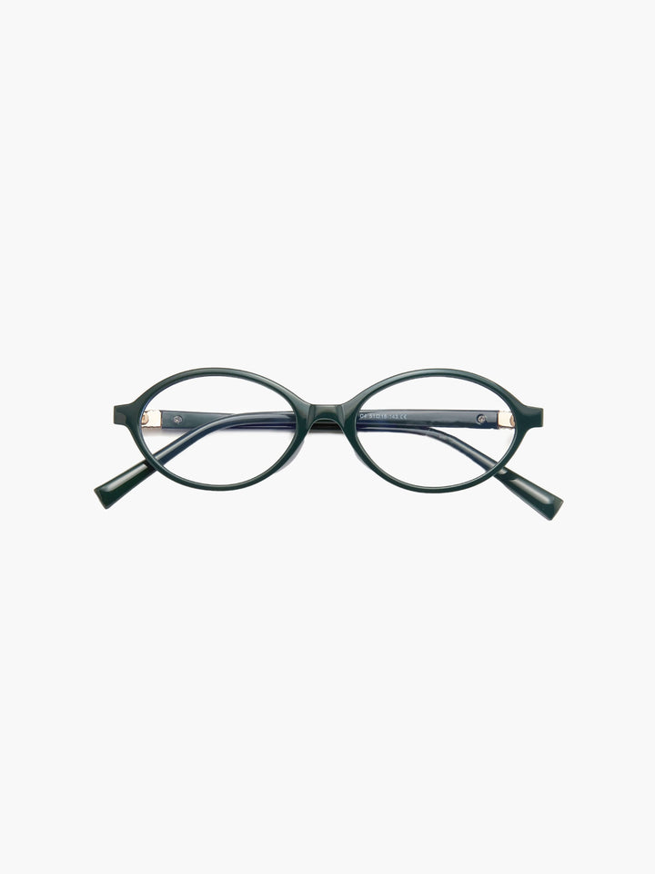 A woman wearing minimalist blue-light reading glasses while relaxing at home.