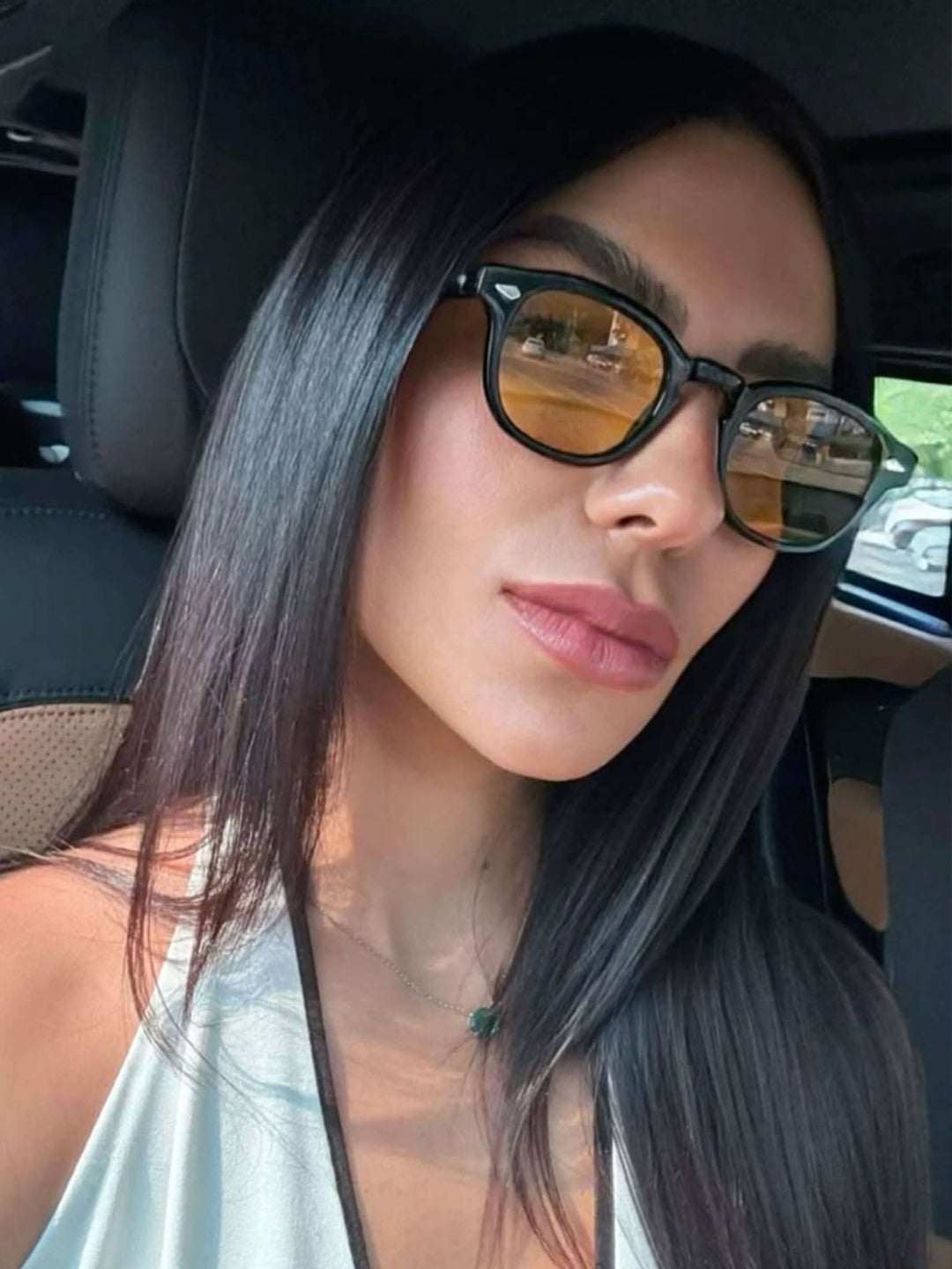 A woman wearing chic round-frame sunglasses on a city walk.