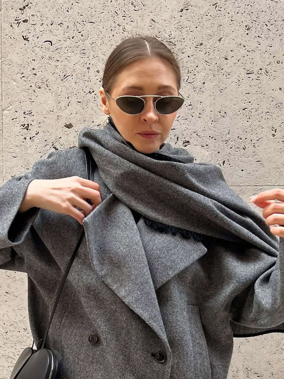 A woman wearing timeless slim black cat-eye sunglasses on an fall day.