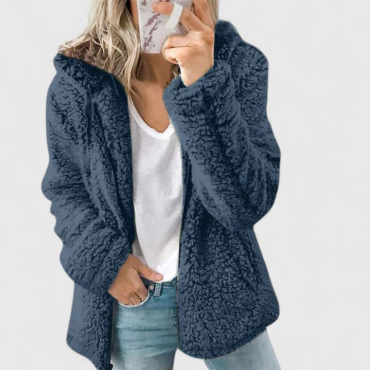 A woman wearing a plush cosy zip jacket over jeans on a cold winter morning.
