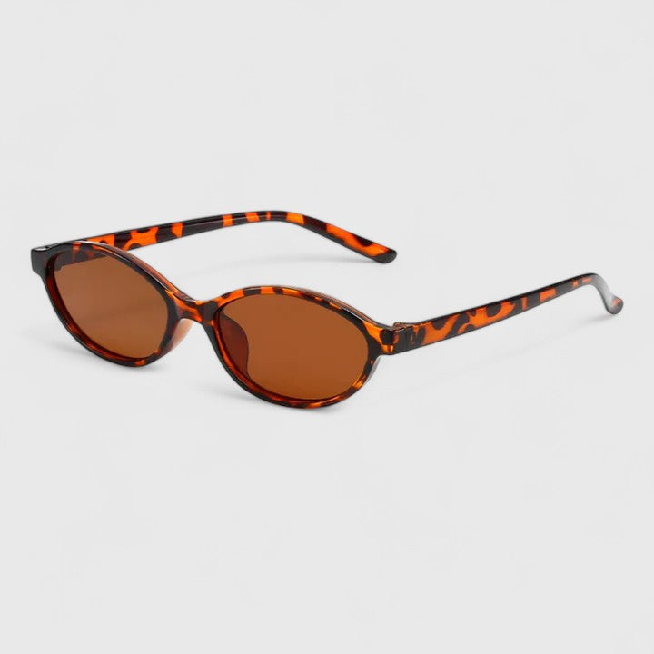 A woman wearing retro oval cat-eye sunglasses on a sunny afternoon.