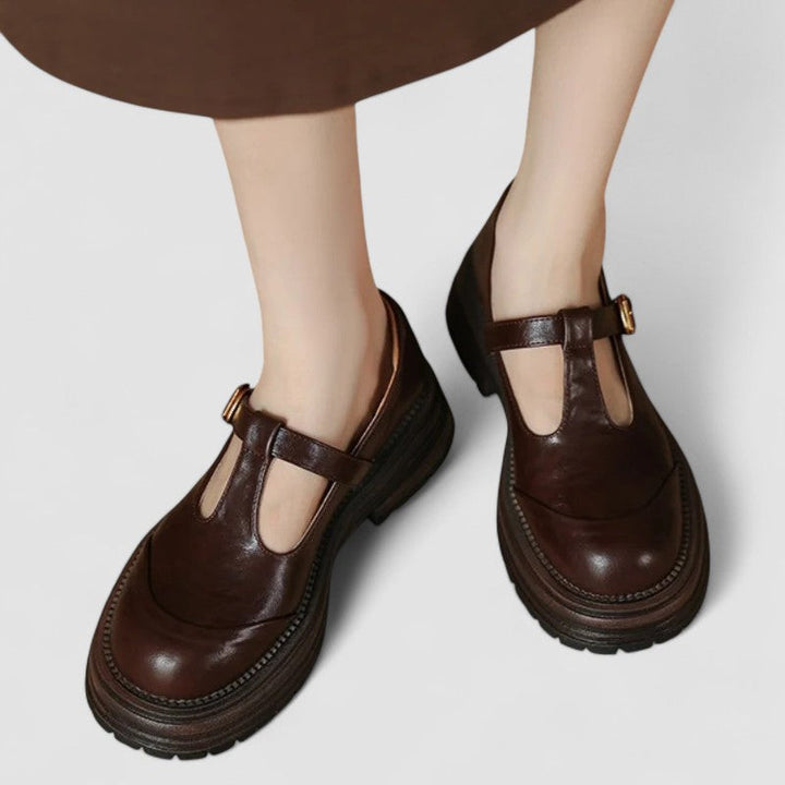 A woman wearing brown T-strap Mary Jane shoes, comfortable on a day around town.