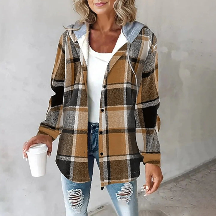 A woman wearing a grey and white checked hooded jacket with a button front