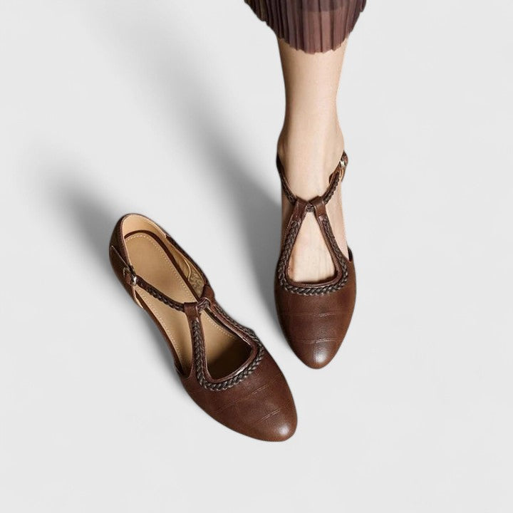 A woman wearing beige T-strap flats, dressed for a special occasion.
