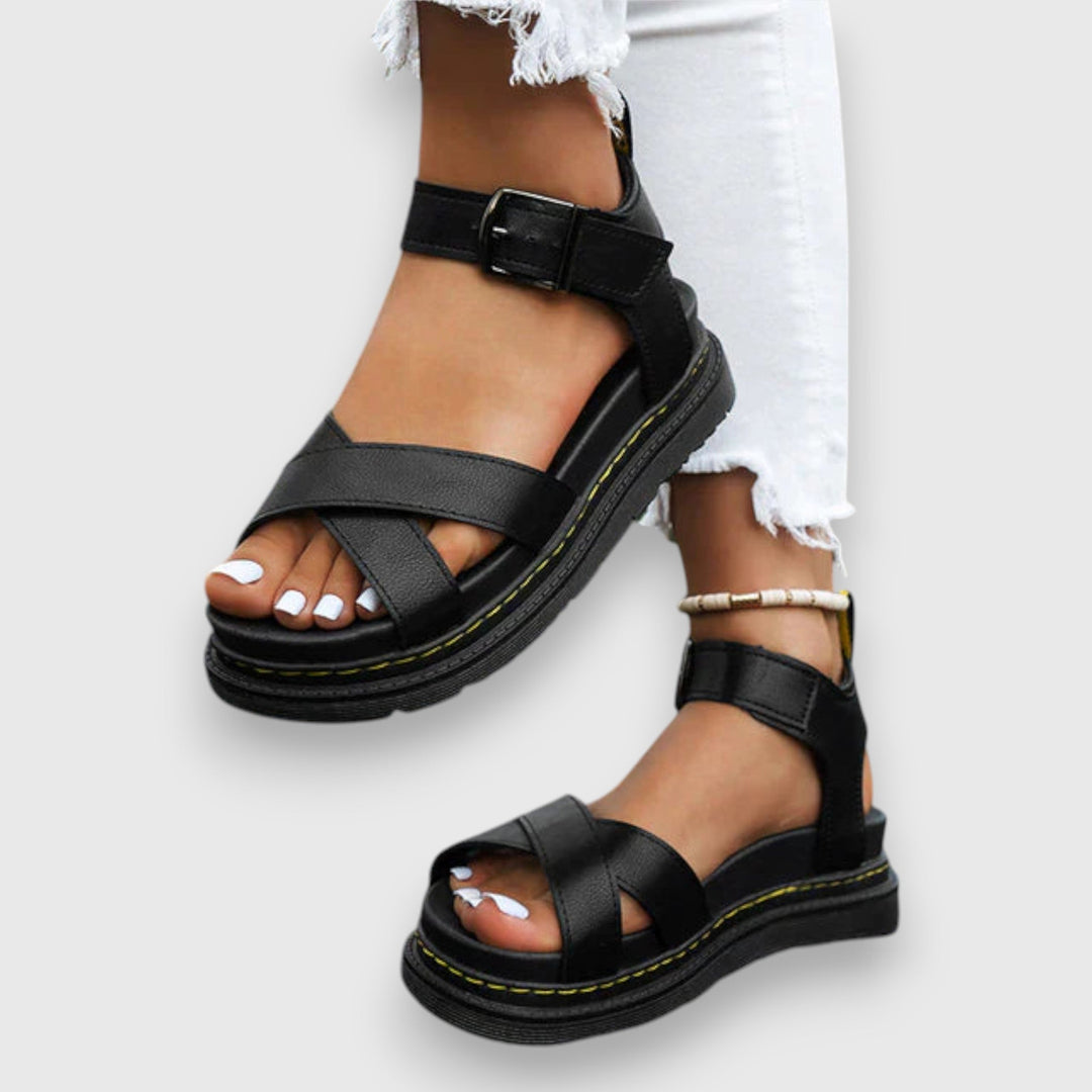 A woman wearing white elegant platform sandals with a broad, cushioned footbed.