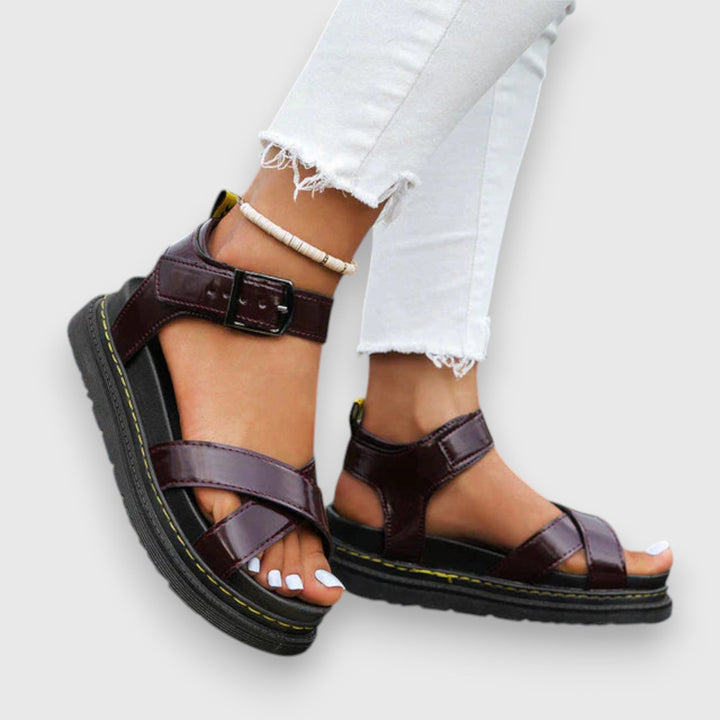 A woman wearing white elegant platform sandals with a broad, cushioned footbed.