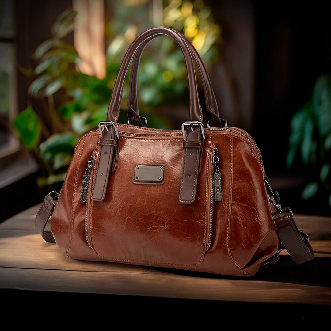 A woman carrying a structured luxury handbag on her arm as she walks through town.