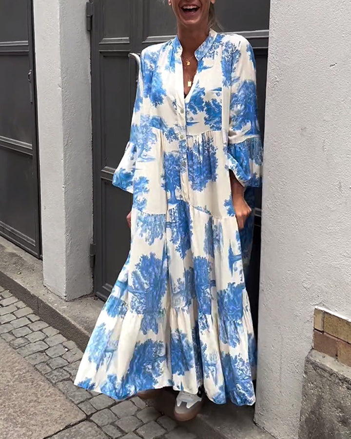 Woman wearing the Sylvie flowing maxi dress with a delicate print and V-neckline, the skirt moving softly as she walks.