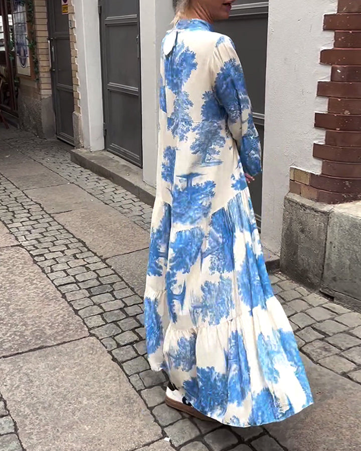 Woman wearing the Sylvie flowing maxi dress with a delicate print and V-neckline, the skirt moving softly as she walks.