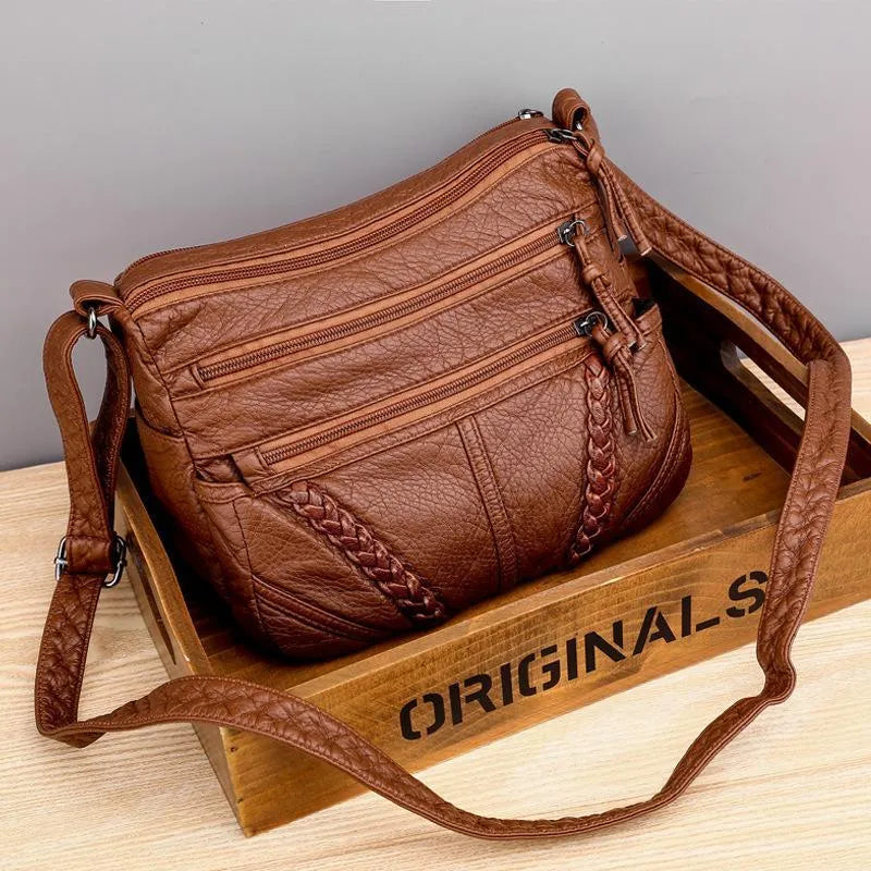 A woman wearing a refined shoulder bag at her hip while out in town.