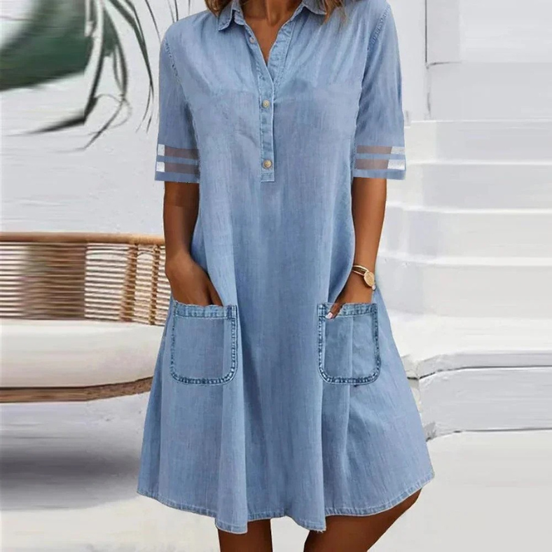 Woman wearing the Kathleen blue button-collar dress with front pockets, strolling through town.