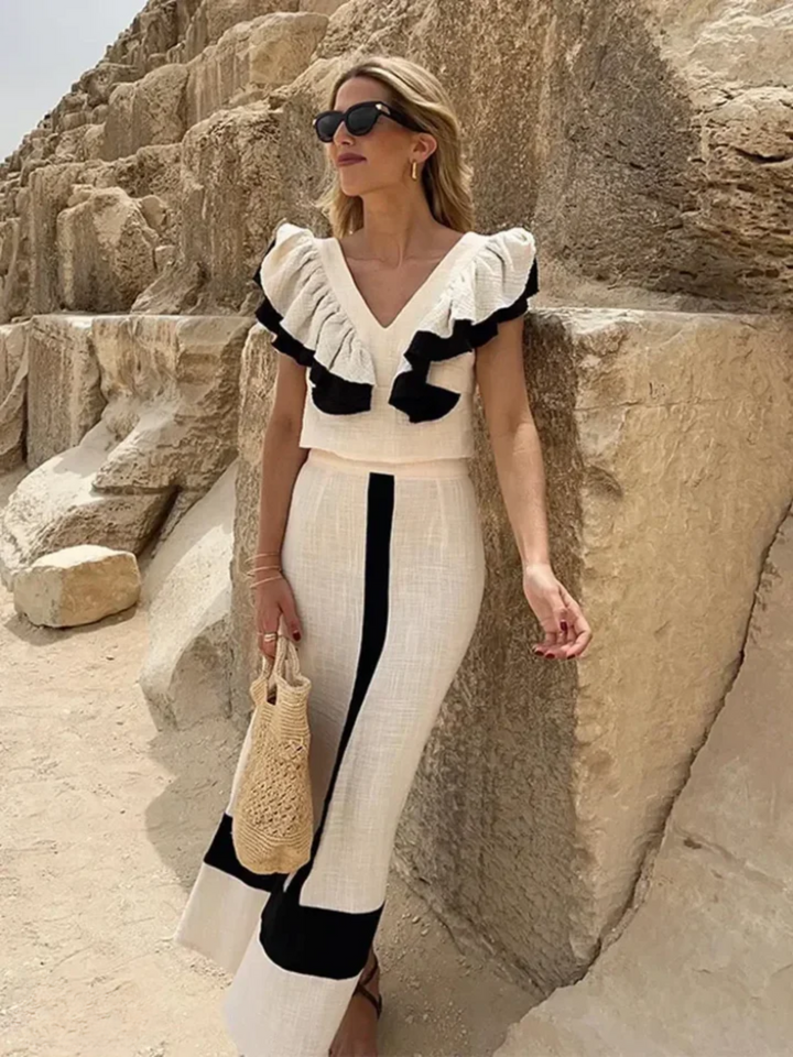 A woman wearing a ruffled top with a tailored skirt in a two-piece set