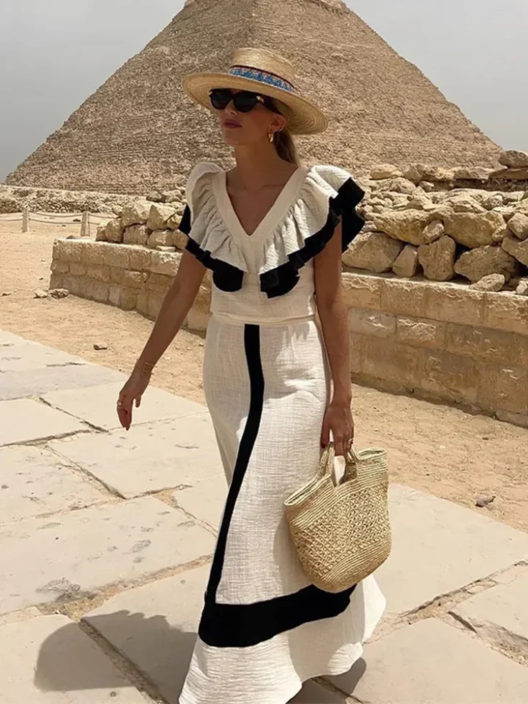 A woman wearing a ruffled top with a tailored skirt in a two-piece set