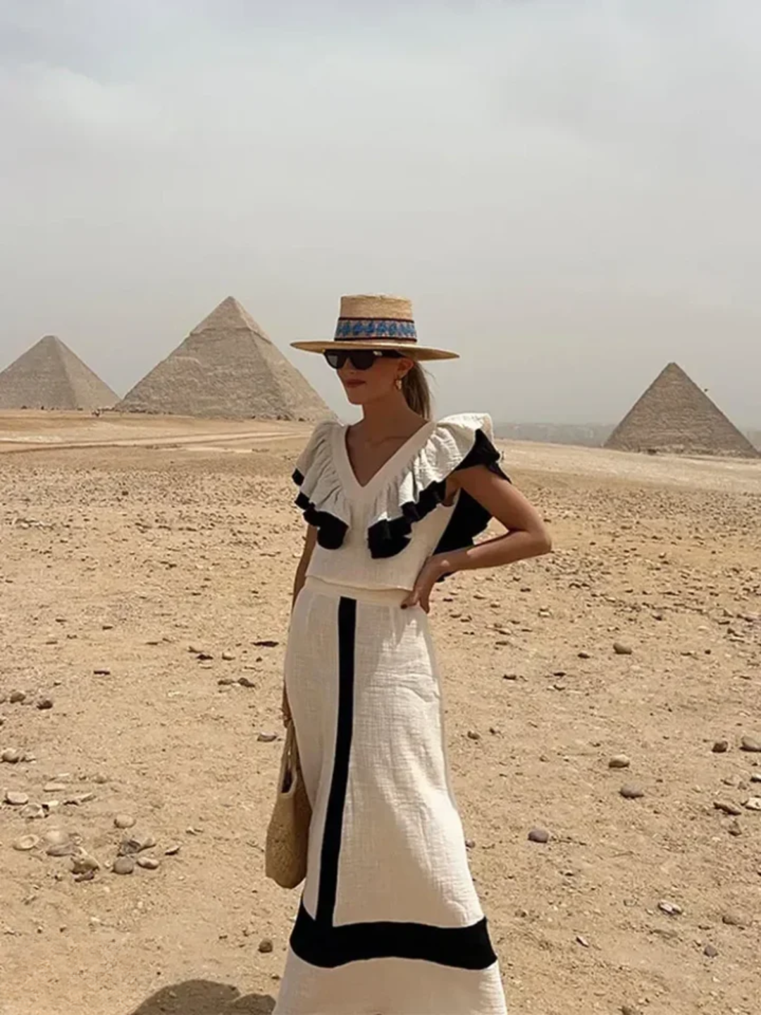 A woman wearing a ruffled top with a tailored skirt in a two-piece set