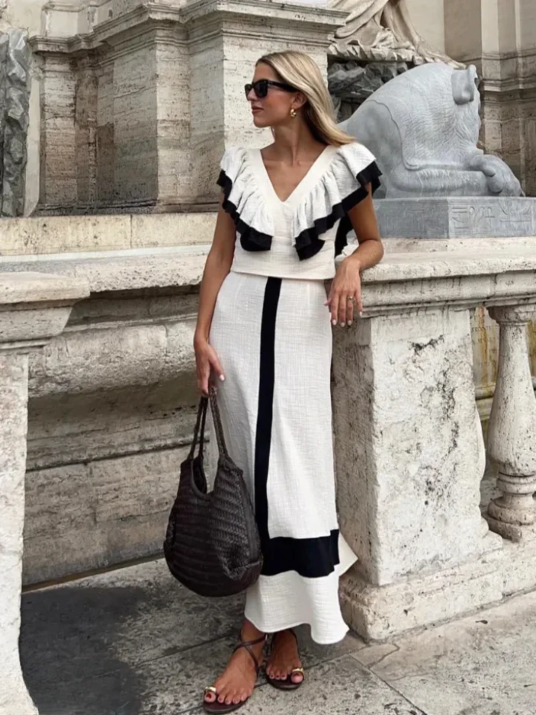 A woman wearing a ruffled top with a tailored skirt in a two-piece set