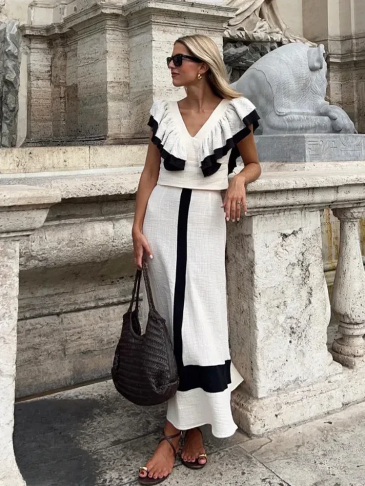 A woman wearing a ruffled top with a tailored skirt in a two-piece set