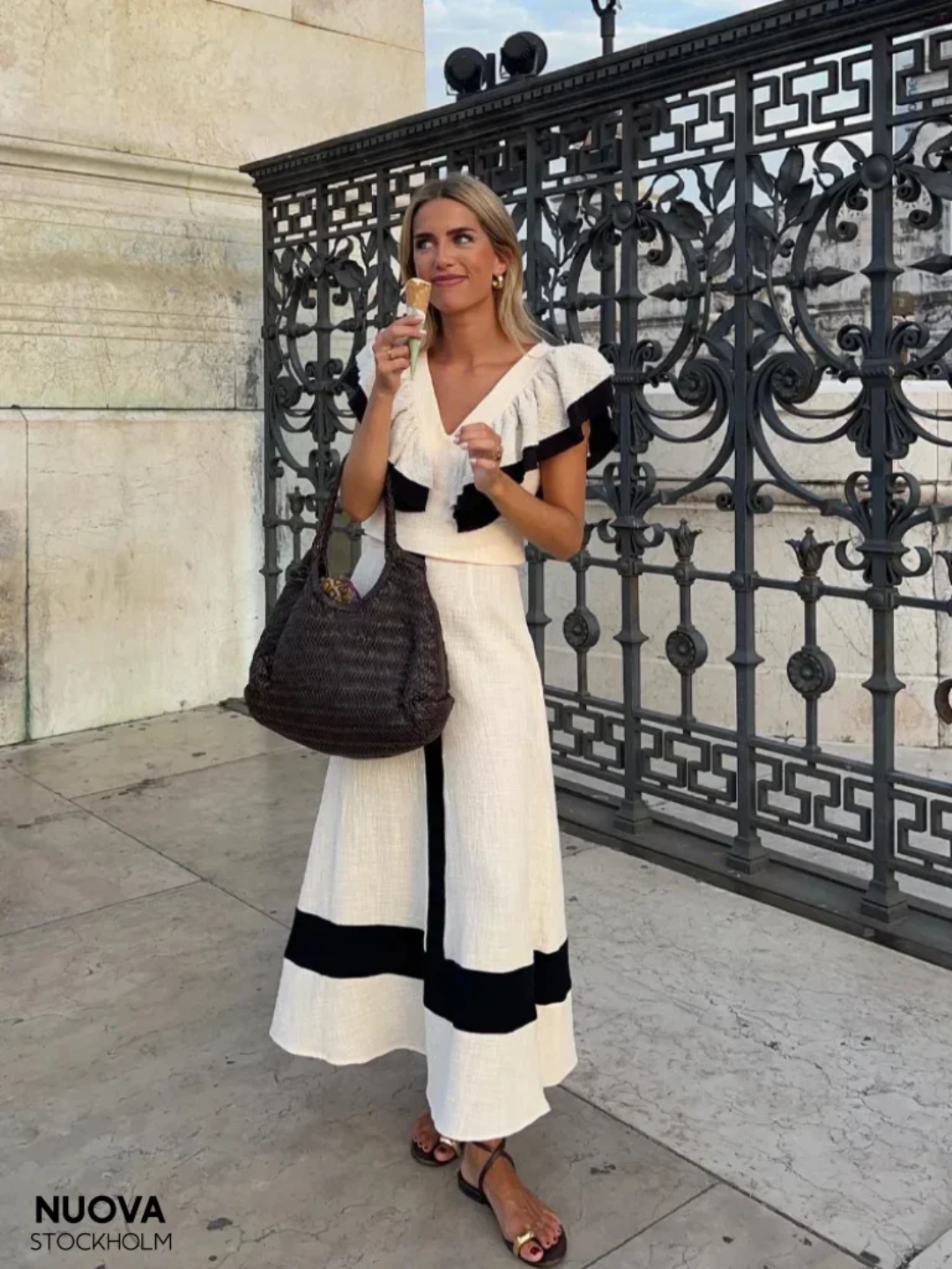 A woman wearing a ruffled top with a tailored skirt in a two-piece set