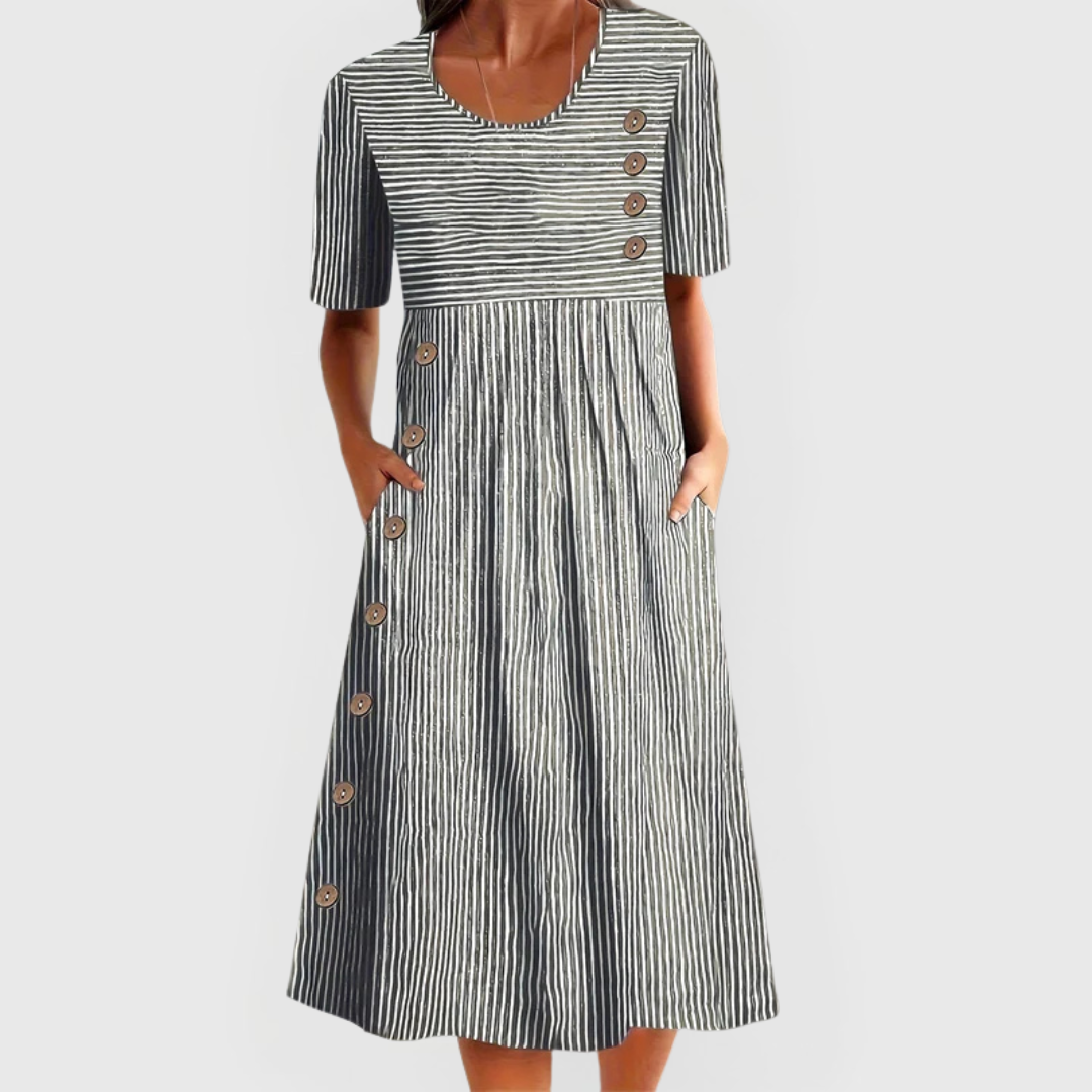 A woman wearing the Helen striped midi dress with button details, standing outdoors on a bright day.
