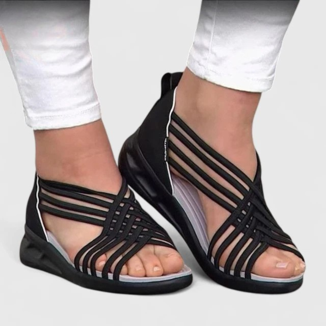 A woman walking with ease in elegant wide-fit everyday sandals with a cushioned footbed.