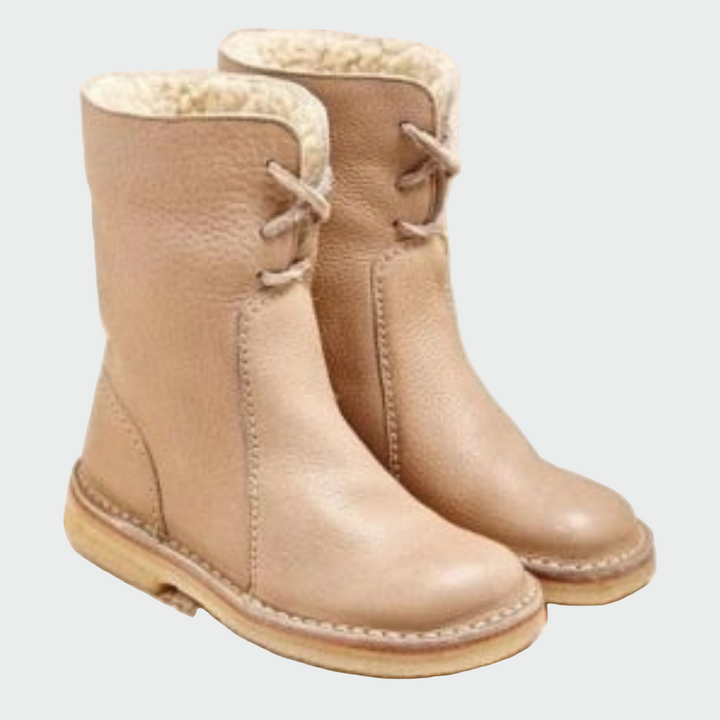 Woman wearing beige warm-lined winter boots on a cold day out.