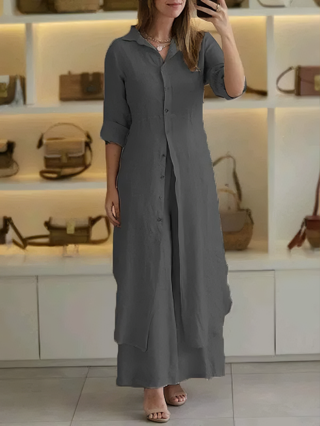 A woman wearing an elegant dress layered with flowing wide-leg pants.