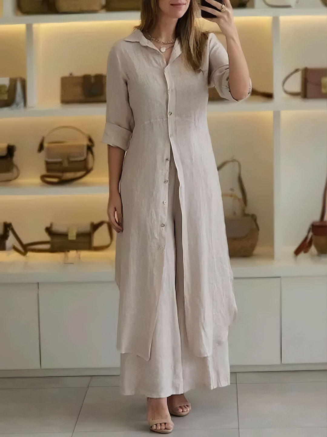 A woman wearing an elegant dress layered with flowing wide-leg pants.