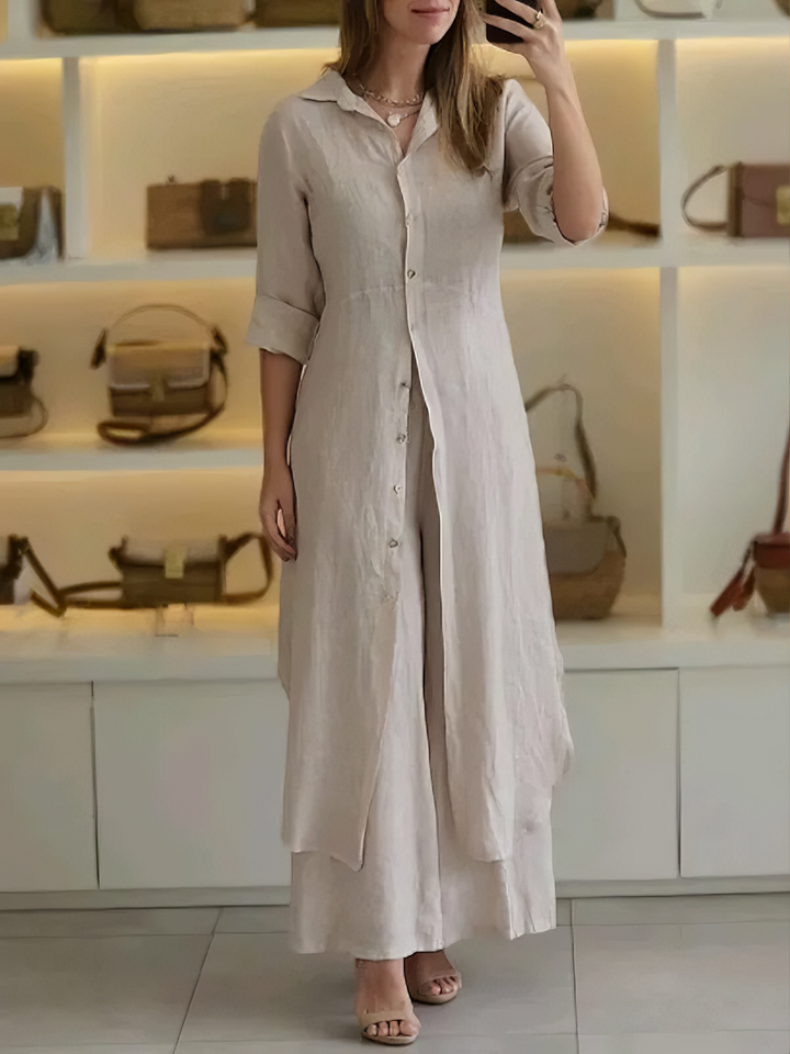 A woman wearing an elegant dress layered with flowing wide-leg pants.