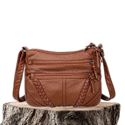 A woman wearing a refined shoulder bag at her hip while out in town.