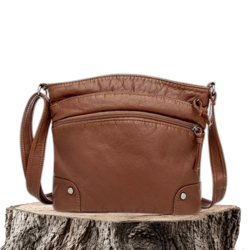 A woman wearing an elegant shoulder bag at her hip while walking through town.