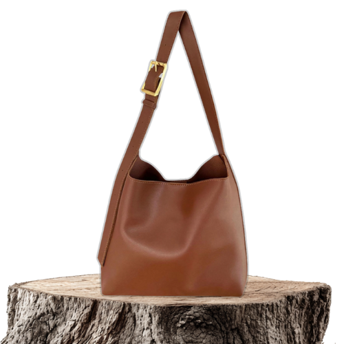 A tan bucket-style shoulder bag with an adjustable buckled strap