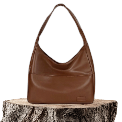 A woman wearing an elegant shoulder bag at her hip while out for the day.