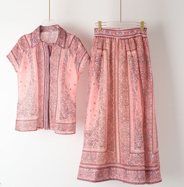 A woman wearing a boho-print top with a flowing midi skirt
