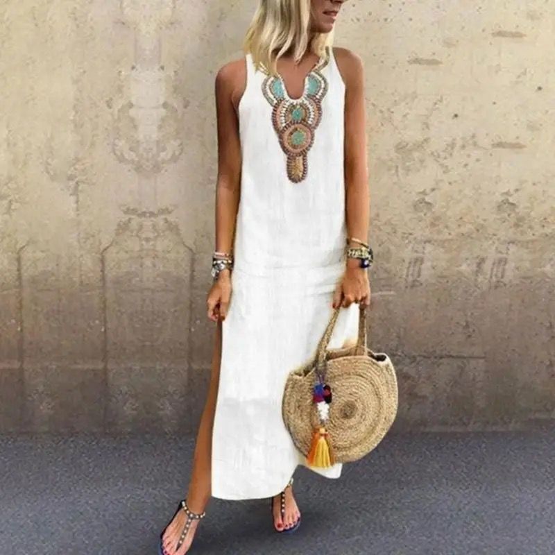 Woman in a sleeveless midi dress with embroidered neckline strolling in the summer sun.