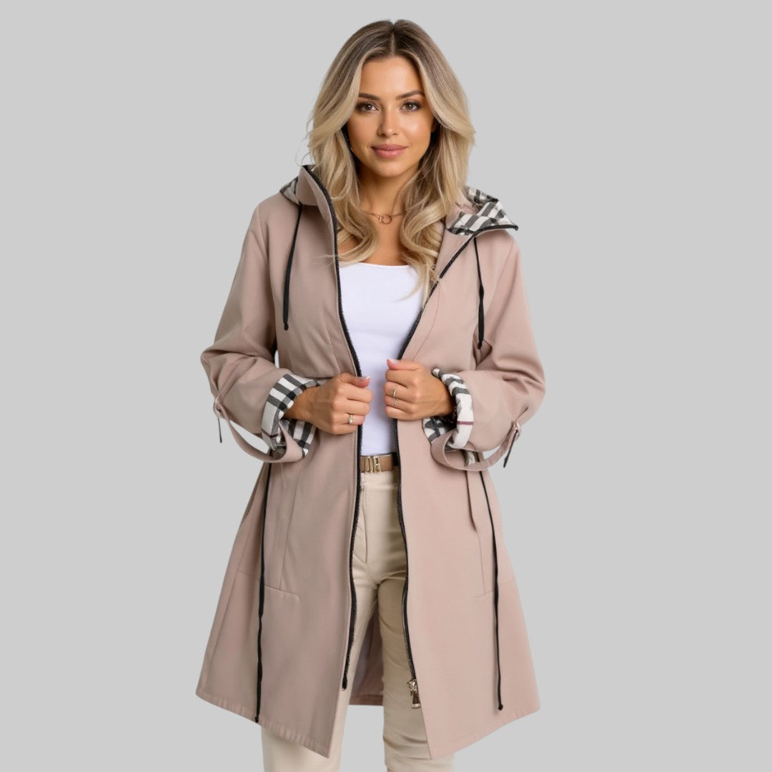 A woman wearing a waisted zip-up coat, standing outdoors on a cold day