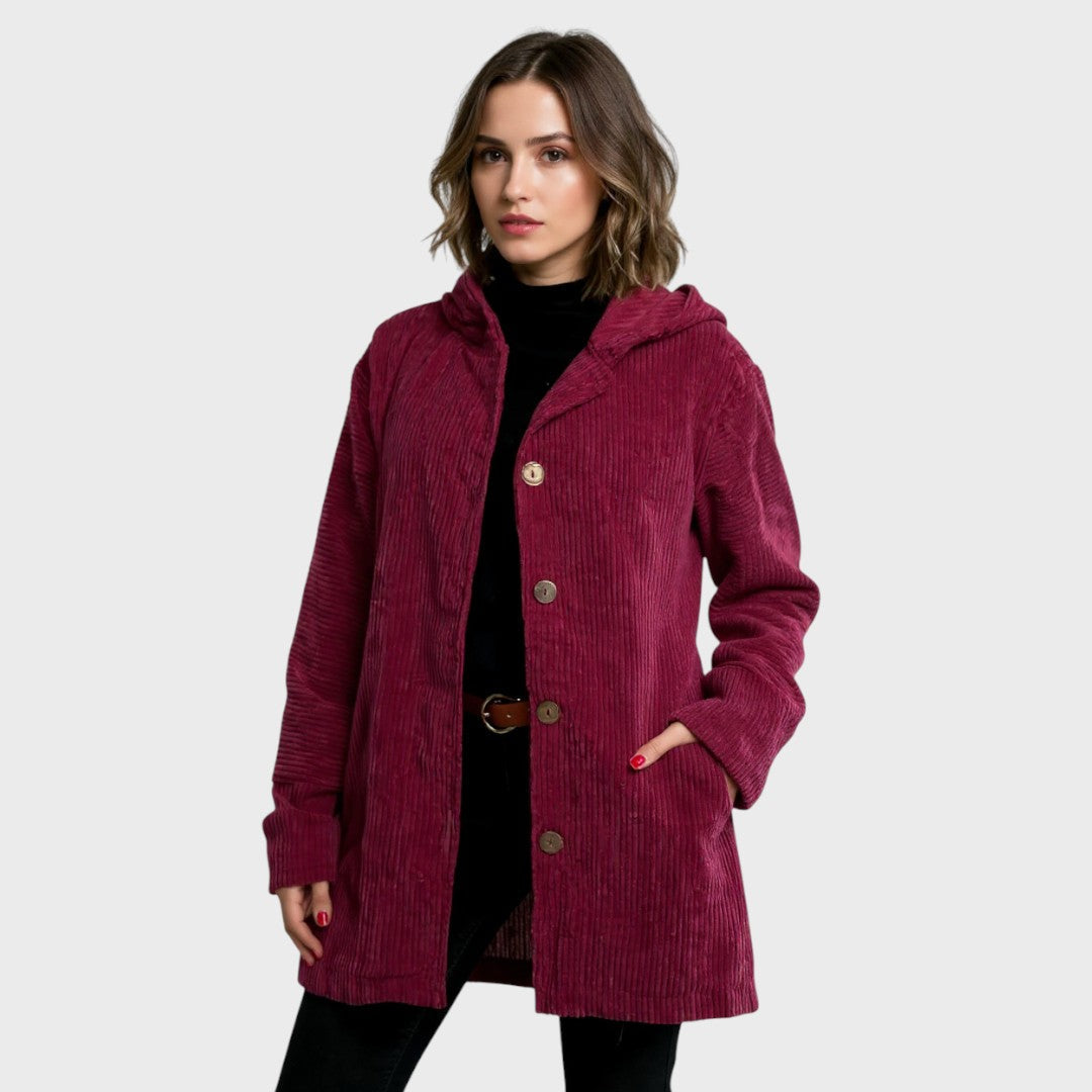A woman wearing a hooded textured jacket outdoors in fall