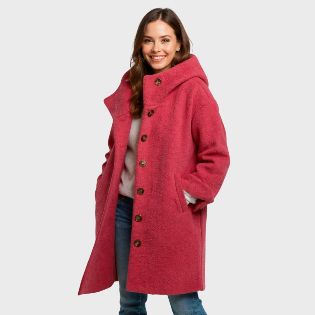 A woman wearing a hooded mid-length coat with wood-look buttons, hands in the side pockets.