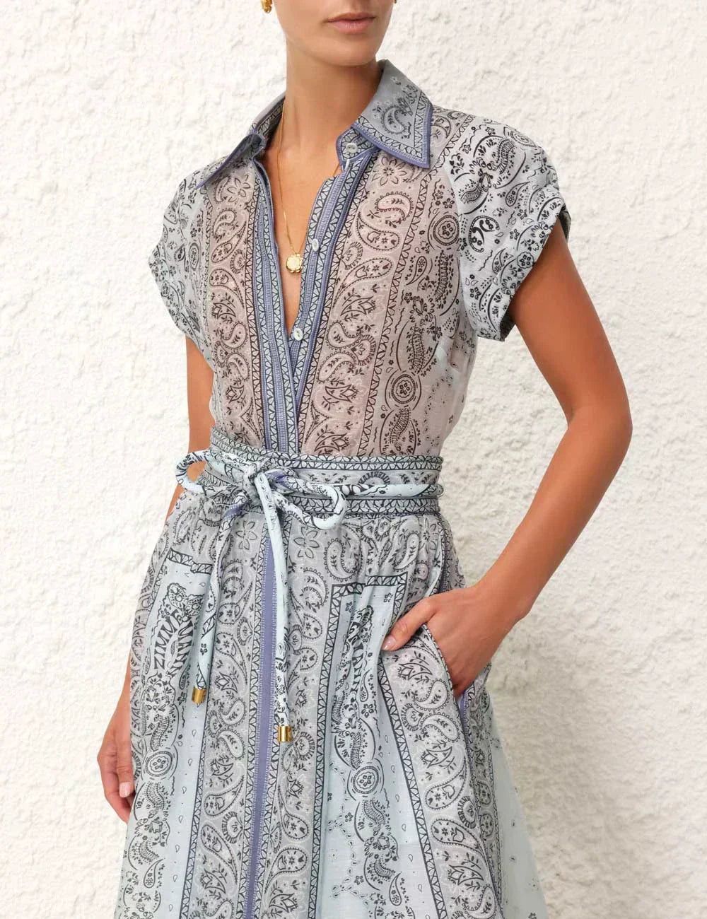 A woman wearing a boho-print top with a flowing midi skirt