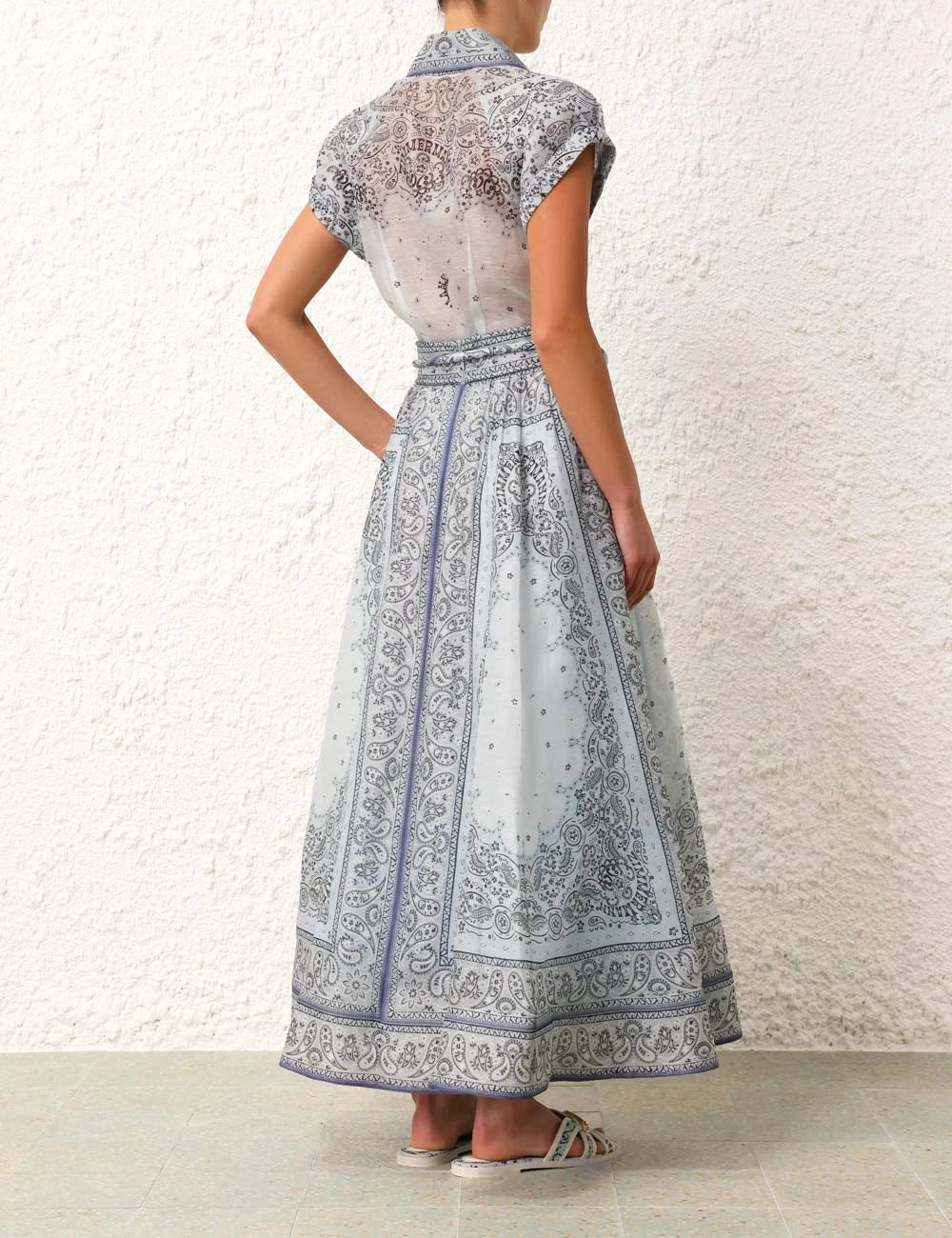 A woman wearing a boho-print top with a flowing midi skirt