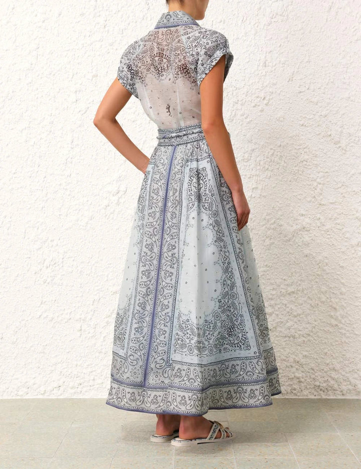 A woman wearing a boho-print top with a flowing midi skirt