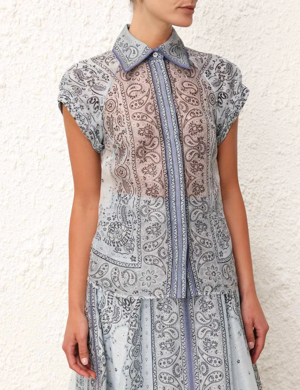 A woman wearing a boho-print top with a flowing midi skirt