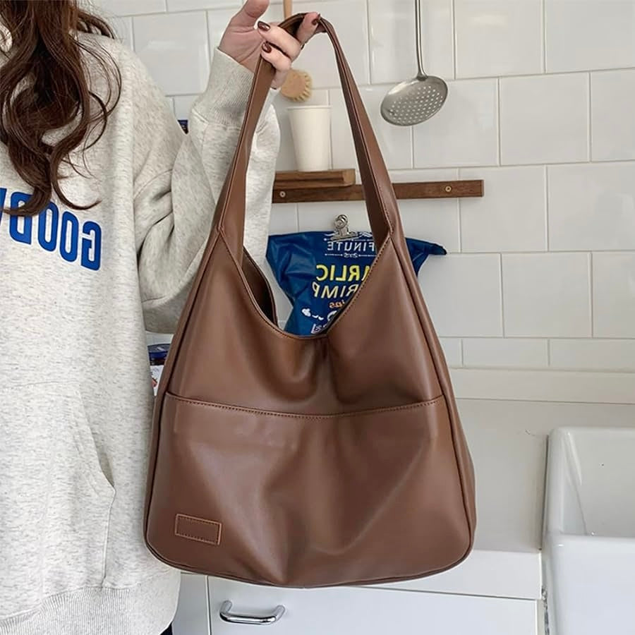 A woman wearing an elegant shoulder bag at her hip while out for the day.