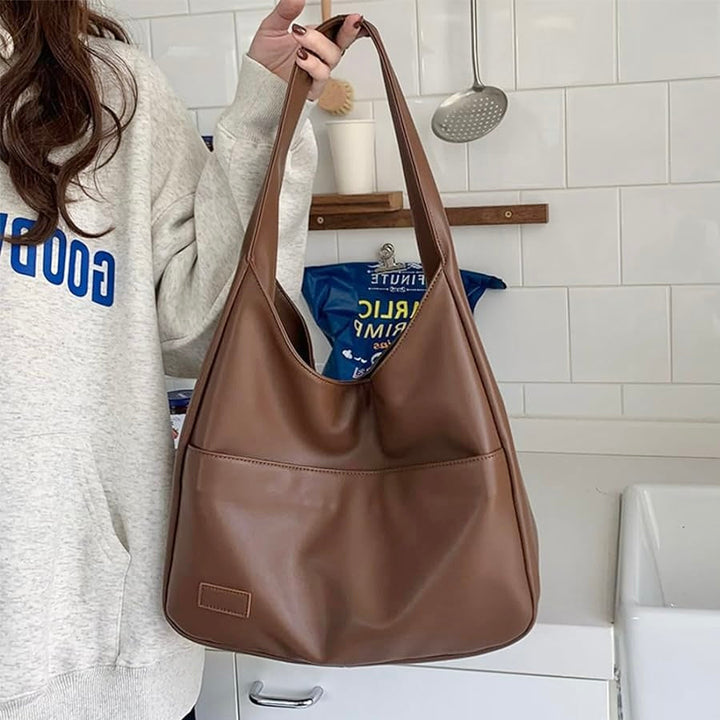 A woman wearing an elegant shoulder bag at her hip while out for the day.