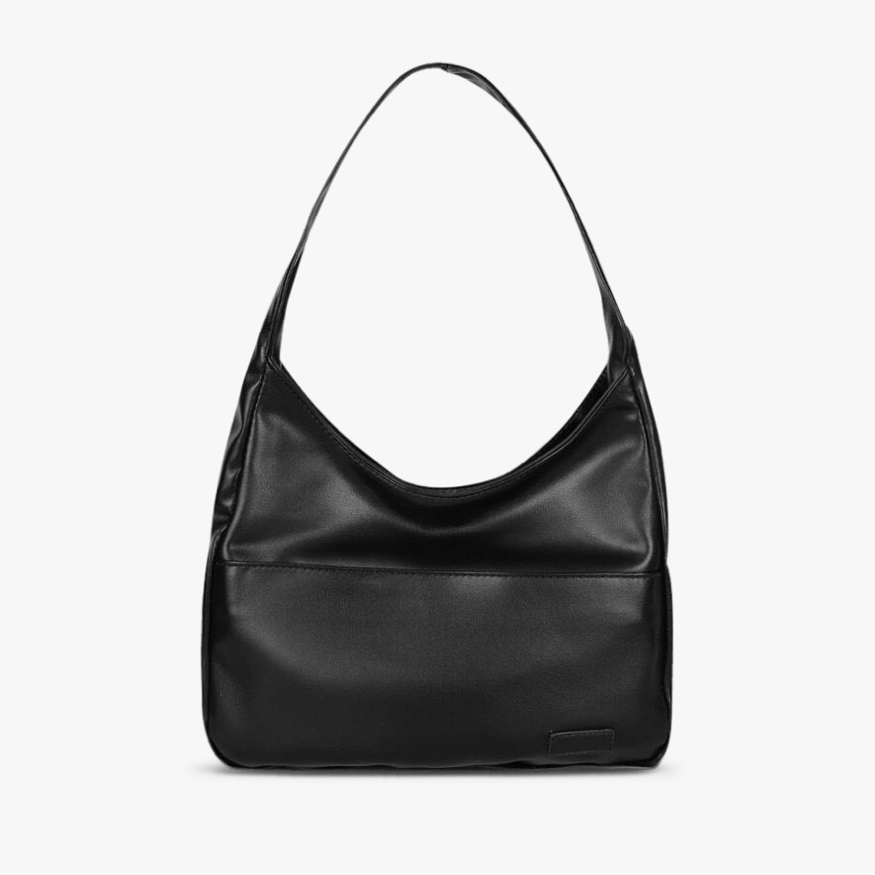 A woman wearing an elegant shoulder bag at her hip while out for the day.