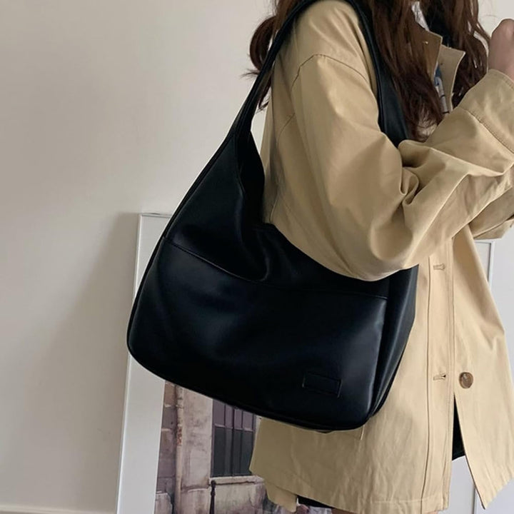 A woman wearing an elegant shoulder bag at her hip while out for the day.