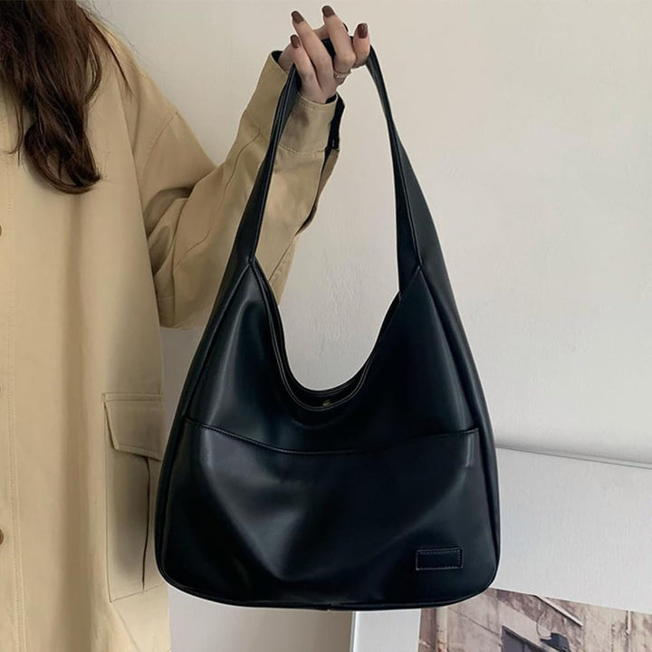 A woman wearing an elegant shoulder bag at her hip while out for the day.