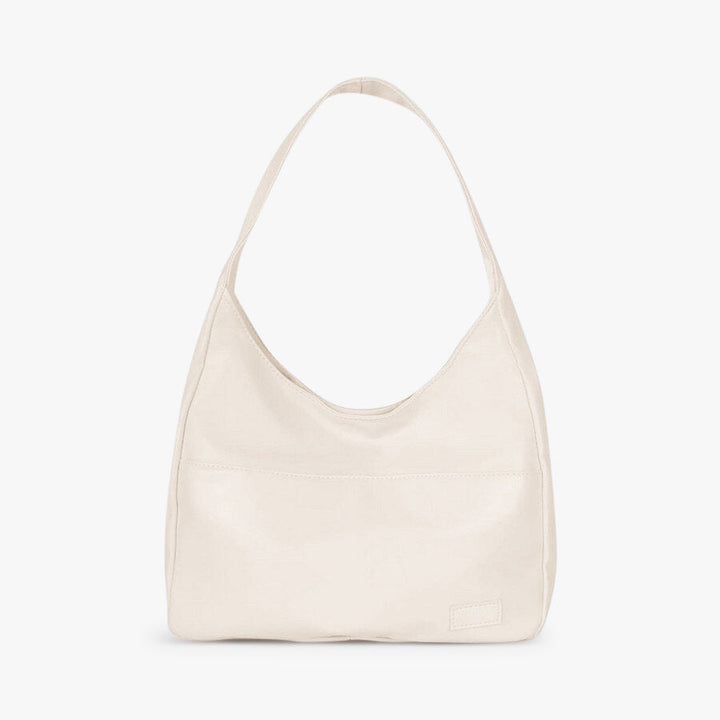 A woman wearing an elegant shoulder bag at her hip while out for the day.