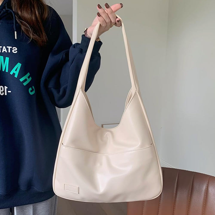 A woman wearing an elegant shoulder bag at her hip while out for the day.