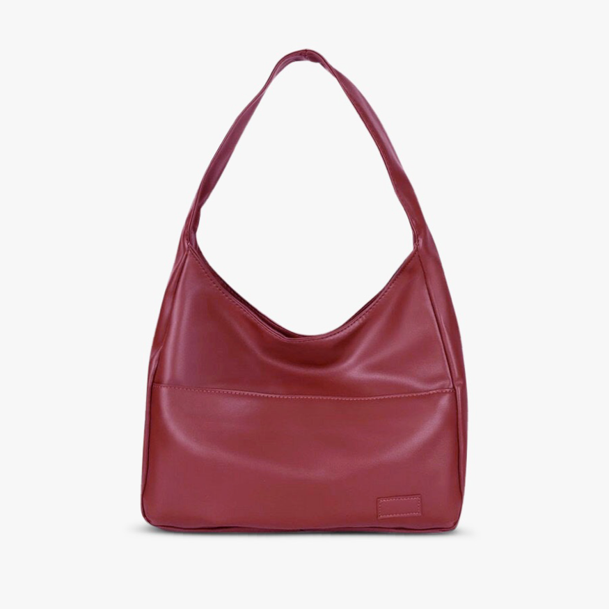 A woman wearing an elegant shoulder bag at her hip while out for the day.