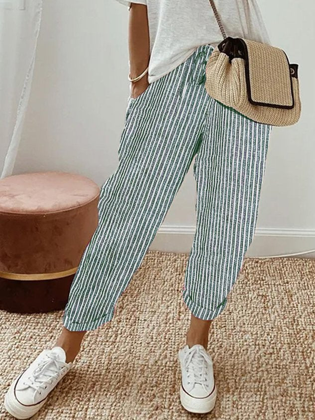 A woman wearing flowing elegant pants with a soft elastic waist and deep pockets.