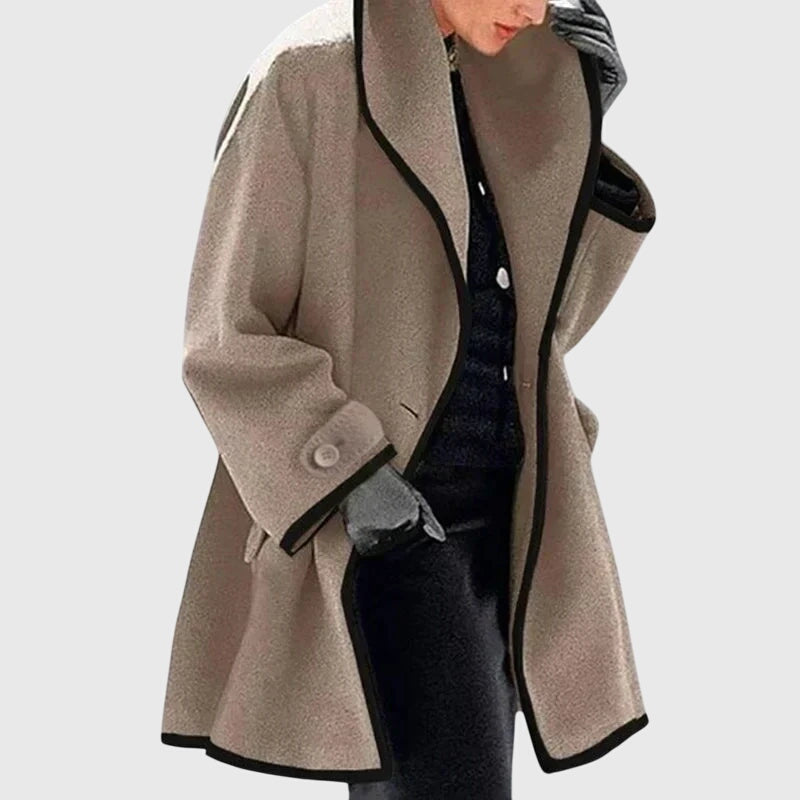 A woman wearing a blue swing-cut jacket with a black contrast trim